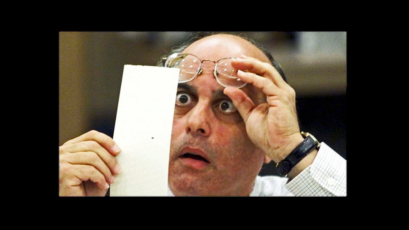 A Florida election official examines a disputed ballot, 2000